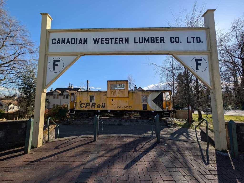 Eine gelbe Lok von CP Rail ist im Freien ausgestellt. Ein kleiner hölzerner Zaun wurde darum gebaut. Ein Schild davor trägt die Aufschrift "Canadian Western Lumber Co. Ltd.". Eine gelbe Lok von CP Rail ist im Freien ausgestellt. Ein kleiner hölzerner Zaun wurde darum gebaut. Ein Schild davor trägt die Aufschrift "Canadian Western Lumber Co. Ltd.".
