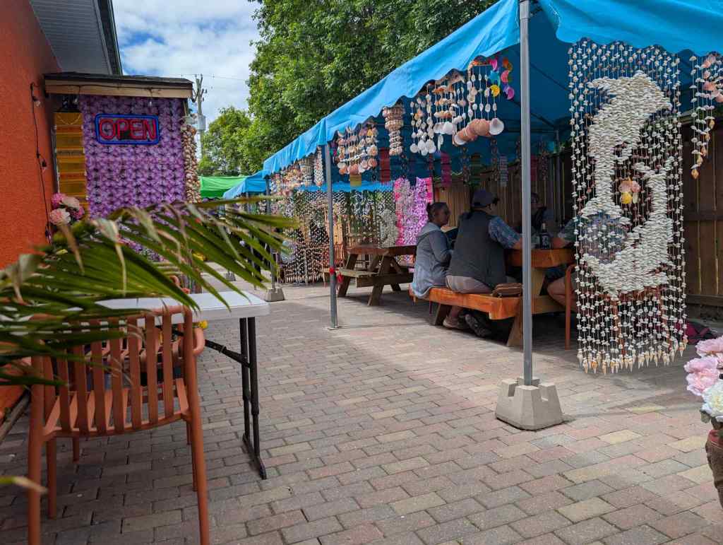 Patio eines Thai-Restaurants mit bunten Muschelvorhängen