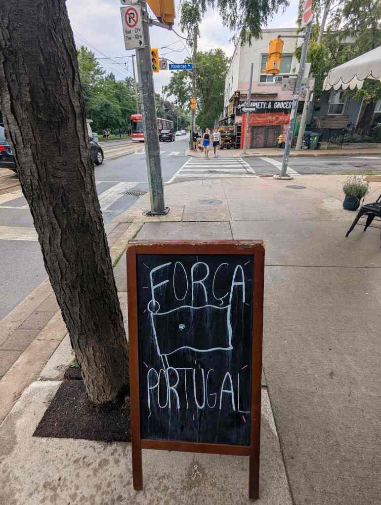 Auf einer Straße steht ein Schild, auf dem "Força Portugal" zur Fußball-WM steht.