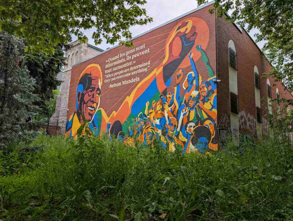 Mural, auf dem Nelson Mandela mit einem Zitat abgebildet ist. Es besagt: "Quand les gens sont déterminés, ils peuvent tout surmonter."